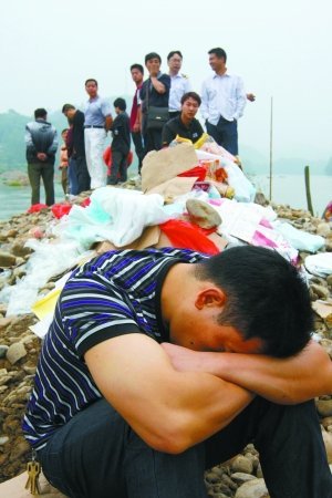 失踪人员的亲属正在现场等待消息。9日，湖南邵阳县塘田市镇一渡口发生沉船事故，救援指挥部称船上共50人，38人获救，11人死亡，另有1人失踪。目前当地已为每名死者家属预付5万元补偿金。郭国权 摄